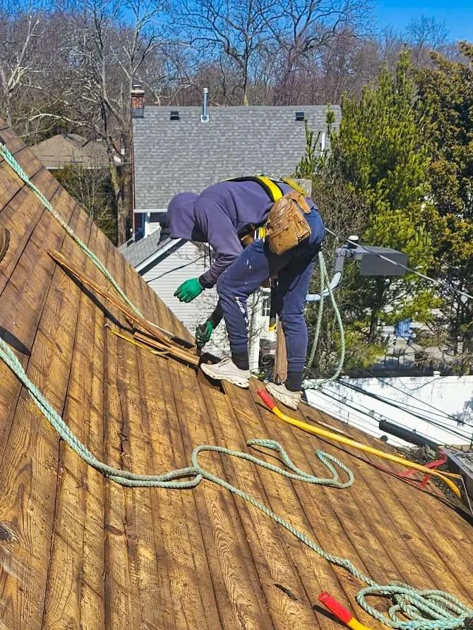 Roofer repairing flashing on a residential roof